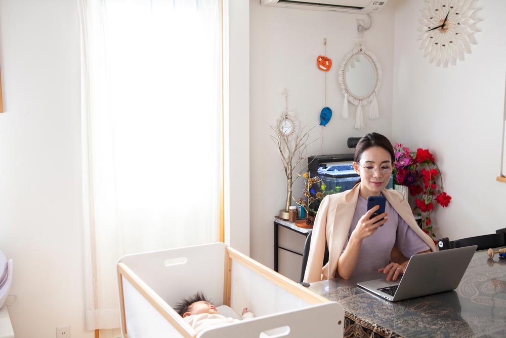Working mum with baby in cot
