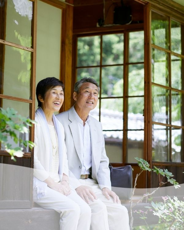 日本への本帰国を見据え、縁側で笑顔で未来を語り合うシニアの日本人ご夫婦